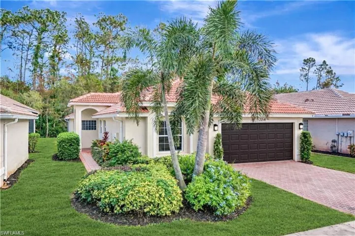 Mediterranean / spanish house with a front lawn, stucco siding, an attached garage, decorative driveway, and a tile roof
