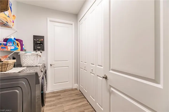 Laundry room featuring plank tile flooring and washing machine and clothes dryer