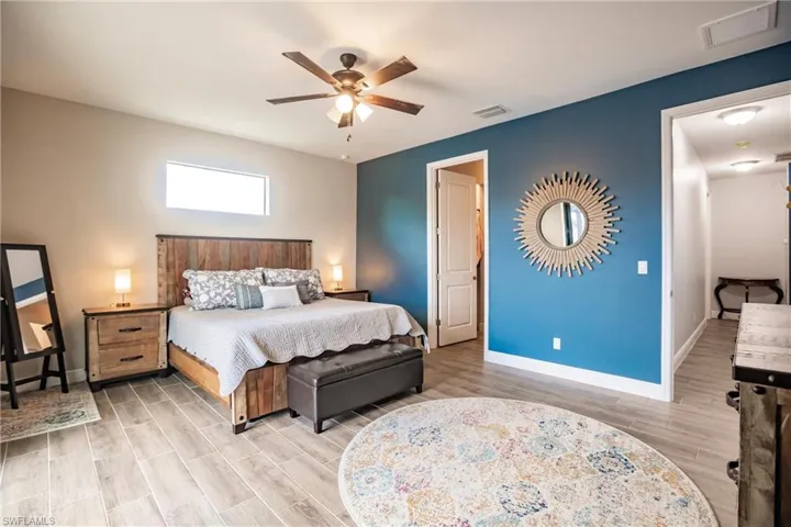 Bedroom featuring ceiling fan and plank tile flooring