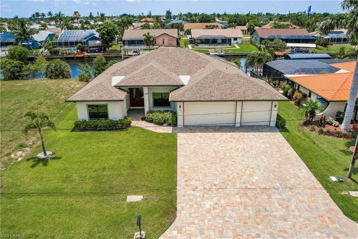 View of front of property featuring a garage, a front yard, and solar panels