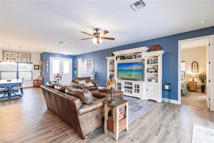 Living room with ceiling fan and plank tile flooring