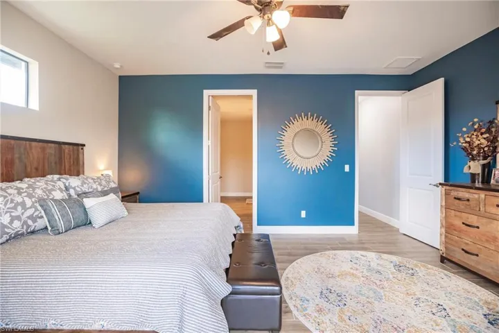 Bedroom with ceiling fan and plank tile flooring