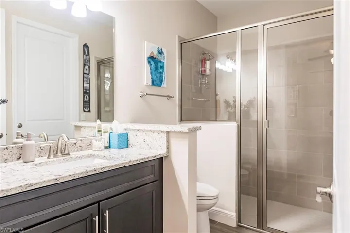 In law suite Bathroom featuring an enclosed shower, vanity, and toilet
