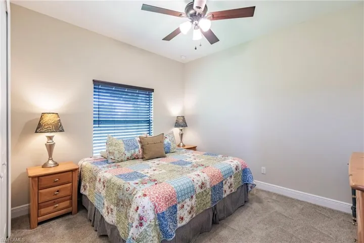 Guest bedroom Carpeted bedroom featuring ceiling fan