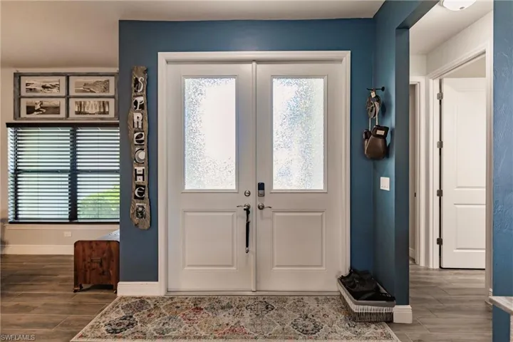 Foyer entrance with plank tile flooring and french doors