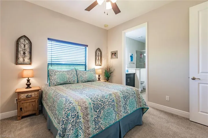 In law suite Carpeted bedroom featuring ceiling fan and connected bathroom