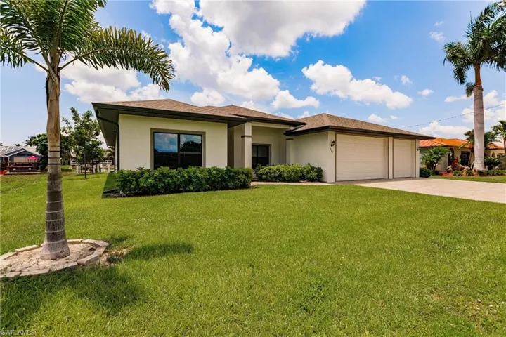 View of front of house with a garage and a front lawn