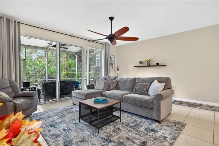 Living room featuring light tile patterned flooring and ceiling fan