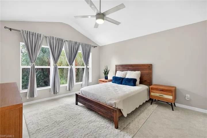 Bedroom with light carpet, lofted ceiling, and ceiling fan