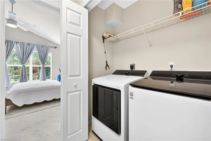 Laundry room with separate washer and dryer, vaulted ceiling, and ceiling fan