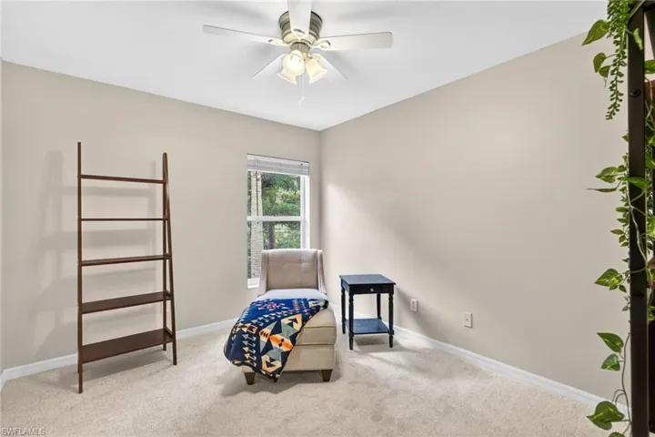 Sitting room with carpet and a ceiling fan