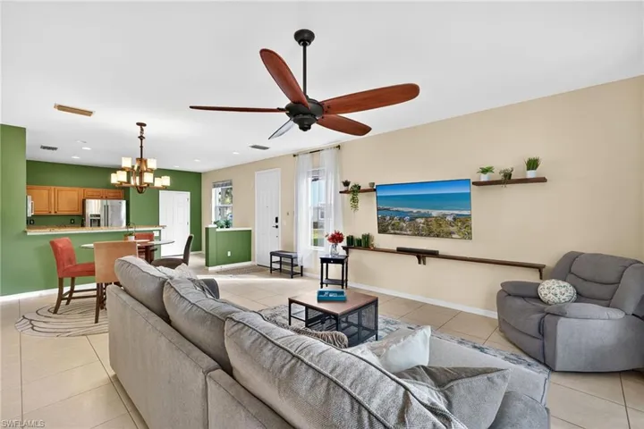 Living room featuring a chandelier, light tile patterned floors, ceiling fan, and recessed lighting