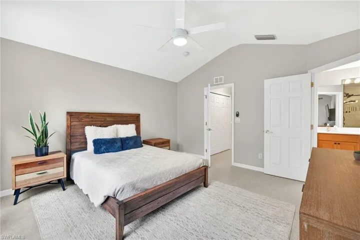 Bedroom featuring lofted ceiling, light carpet, and a ceiling fan