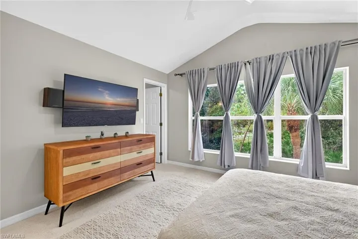 Bedroom with carpet flooring, vaulted ceiling, and a ceiling fan