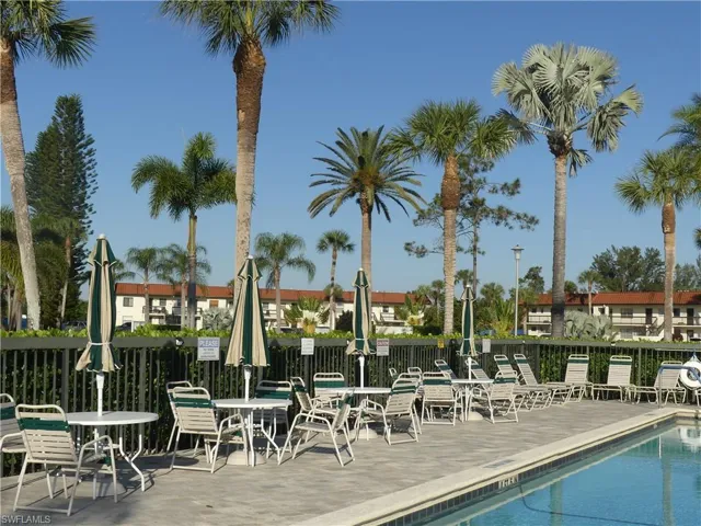 TABLES WITH UMBRELLAS ON POOL DECK