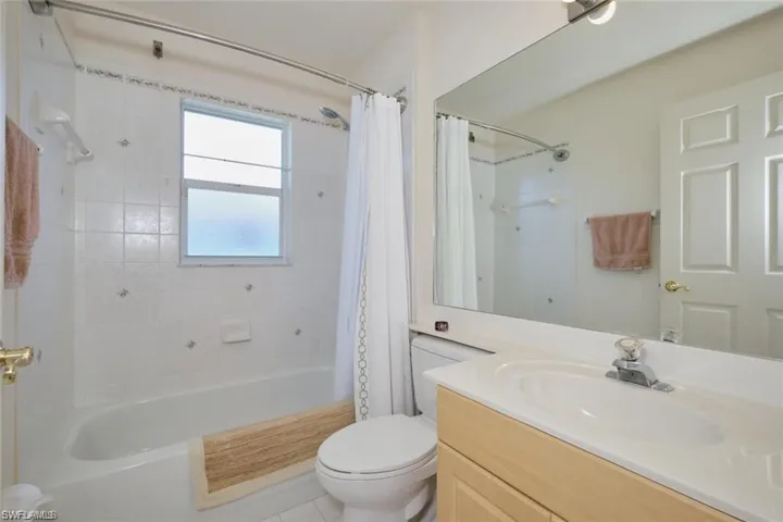 Bathroom featuring toilet, vanity, and shower / bath combination with curtain