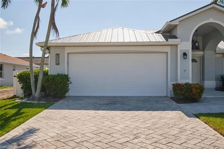 View of front of home featuring driveway, stucco siding, and a garage