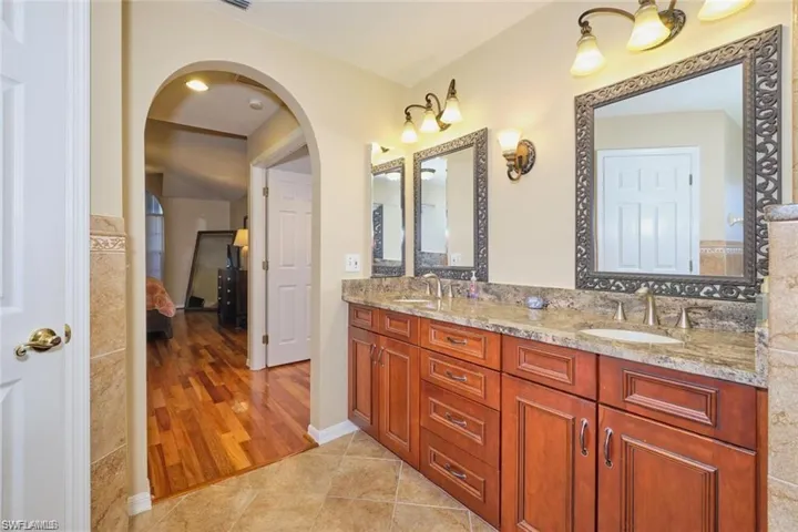 Ensuite bathroom with tile patterned floors, double vanity, ensuite bathroom, and a sink