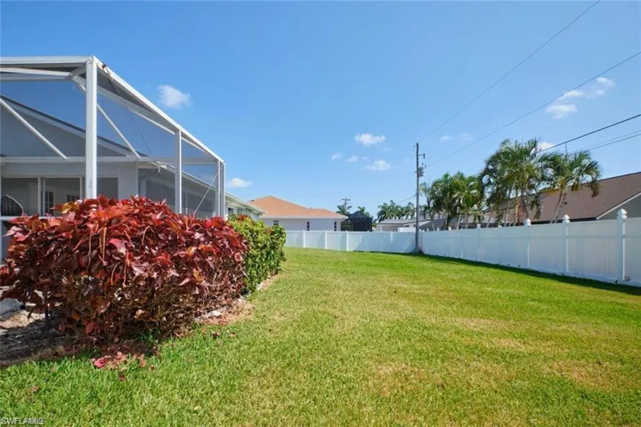 View of yard featuring glass enclosure and fence