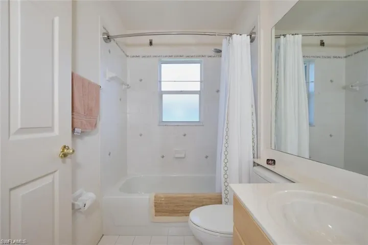 Bathroom with shower / tub combo with curtain, vanity, toilet, and tile patterned flooring