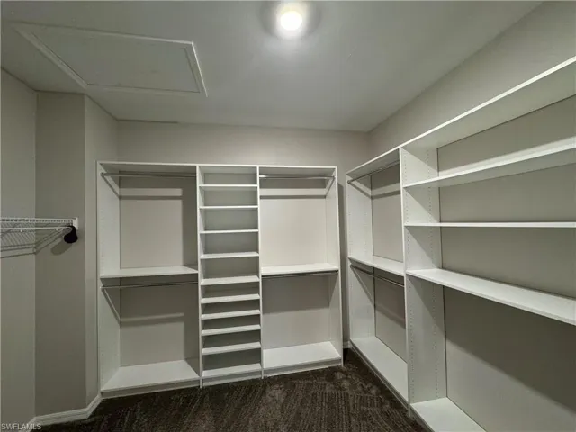 Walk in closet with organizers.