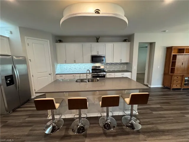 Island kitchen with stainless steel appliances. Natural gas stove.