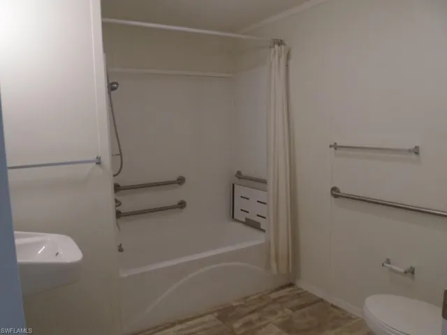 Full bathroom with shower / bathtub combination with curtain and toilet