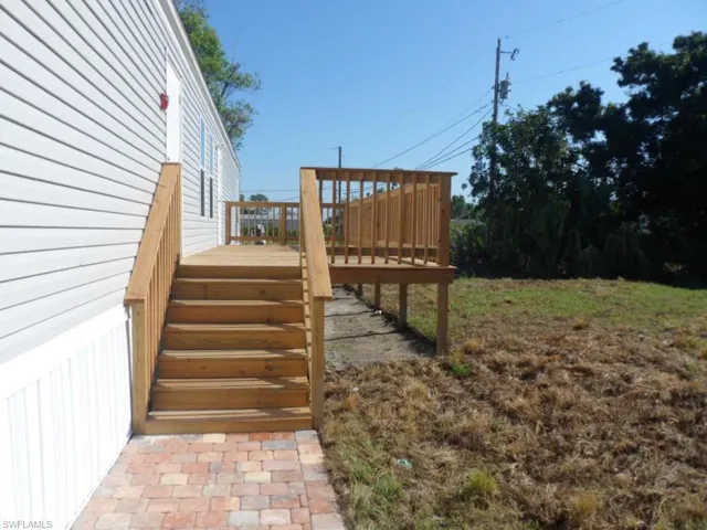 View of yard featuring stairway and a wooden deck and paved walkway