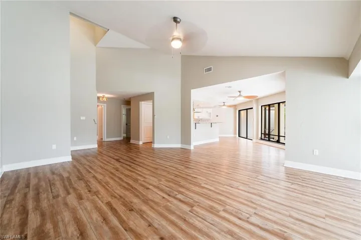 Unfurnished living room with high vaulted ceiling, ceiling fan, and light hardwood / wood-style floors