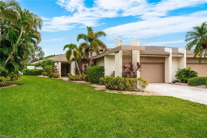 View of front of property with a garage and a front lawn
