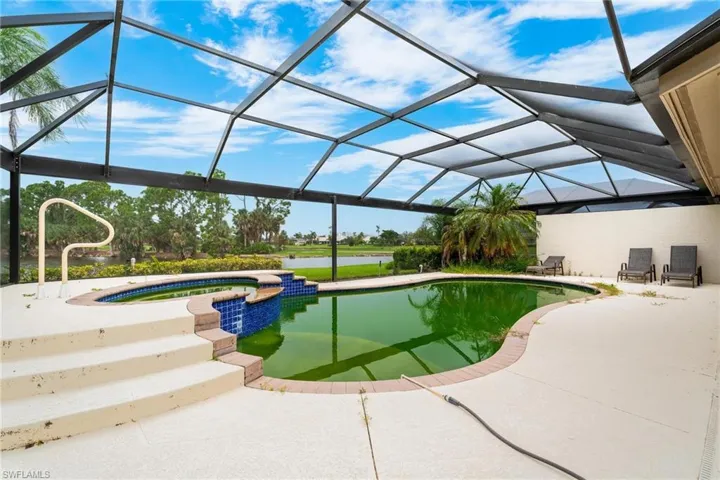View of swimming pool featuring a water view, an in ground hot tub, a patio, and glass enclosure