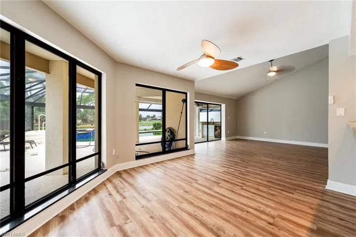 Empty room with vaulted ceiling, hardwood / wood-style floors, and ceiling fan