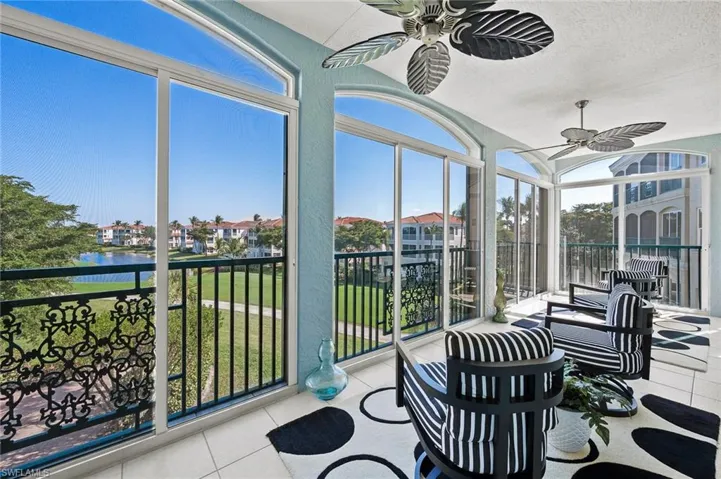 Sunroom featuring a water view and a ceiling fan