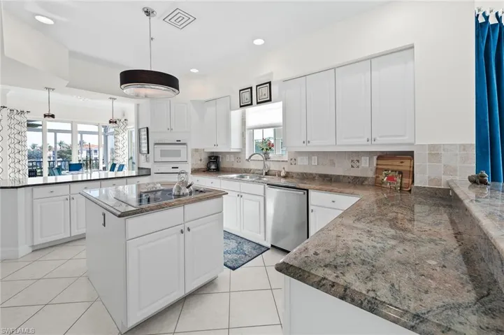 Kitchen featuring white cabinets, dishwasher, and a center island