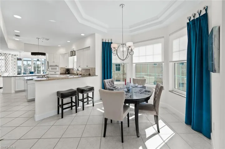 Dining area featuring a chandelier, light tile patterned floors, and ornamental molding