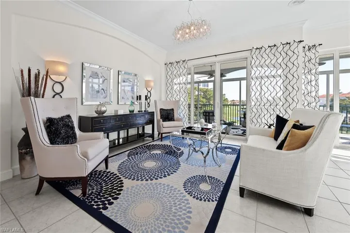 Living area featuring ornamental molding, light tile patterned floors, and hanging lights