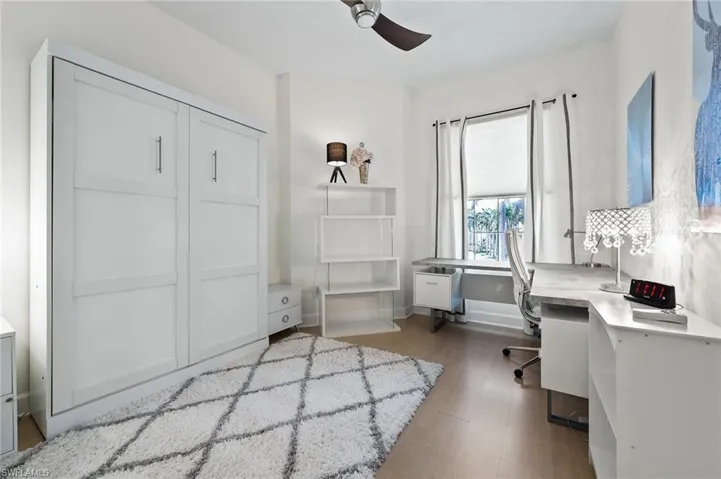 Office area with a ceiling fan and light wood-style floors