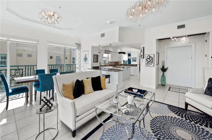Living area featuring hanging lights, ornamental molding, and light tile patterned floors