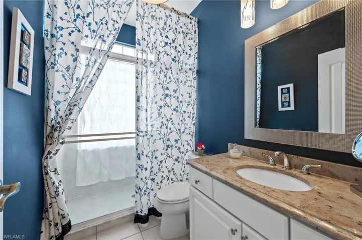 Full bathroom with a stall shower, vanity, and light tile patterned flooring