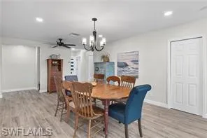 Dining space featuring a chandelier, light wood finished floors, ceiling fan, and recessed lighting