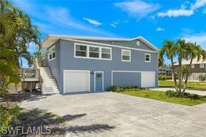 View of front of property with a garage, stairs, decorative driveway, and stucco siding
