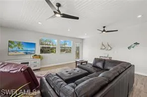 Cinema room with ceiling fan, light wood finished floors, and recessed lighting