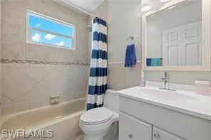 Full bath featuring vanity and shower / bathtub combination with curtain