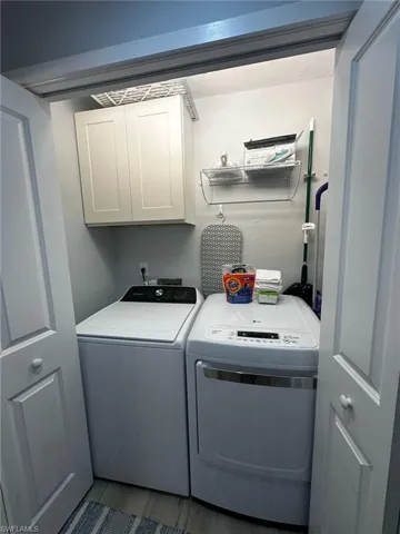 Washroom featuring cabinet space and independent washer and dryer
