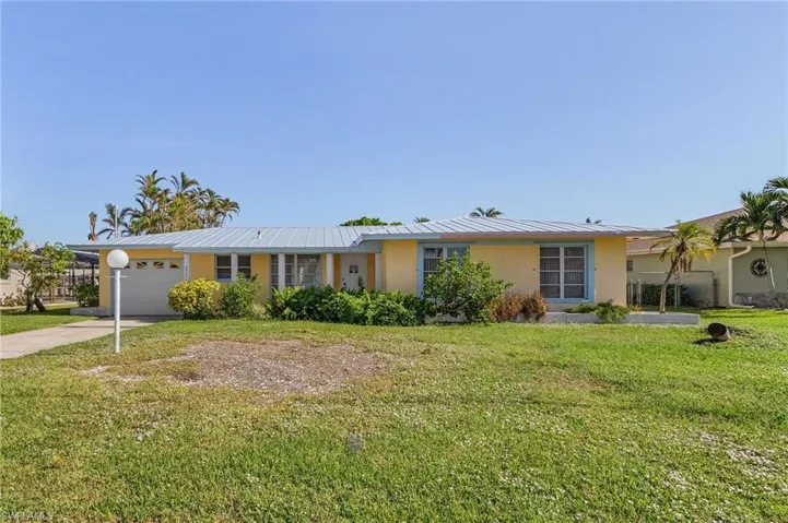 Ranch-style home with a garage and a front lawn