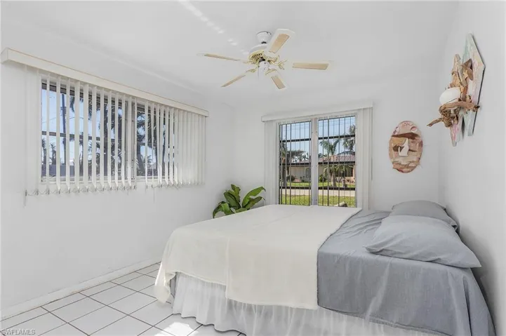 Bedroom with ceiling fan and light tile floors