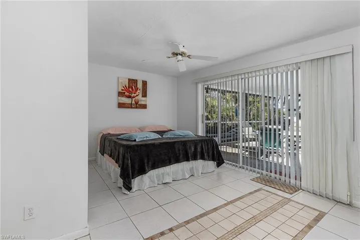 Bedroom featuring access to outside, ceiling fan, and light tile floors