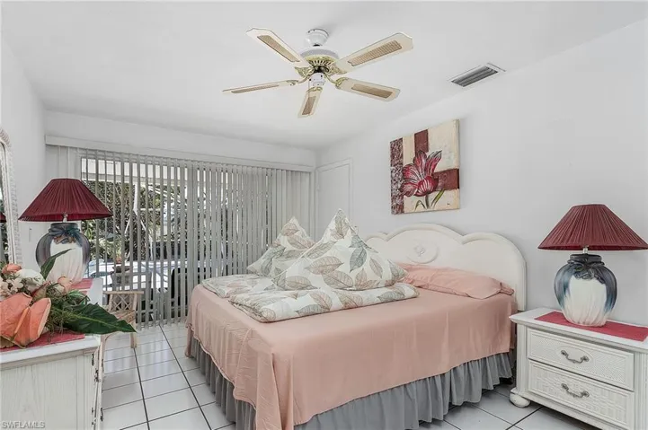 Tiled bedroom featuring ceiling fan