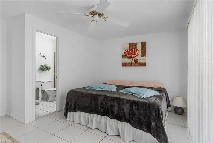Tiled bedroom with ensuite bath and ceiling fan