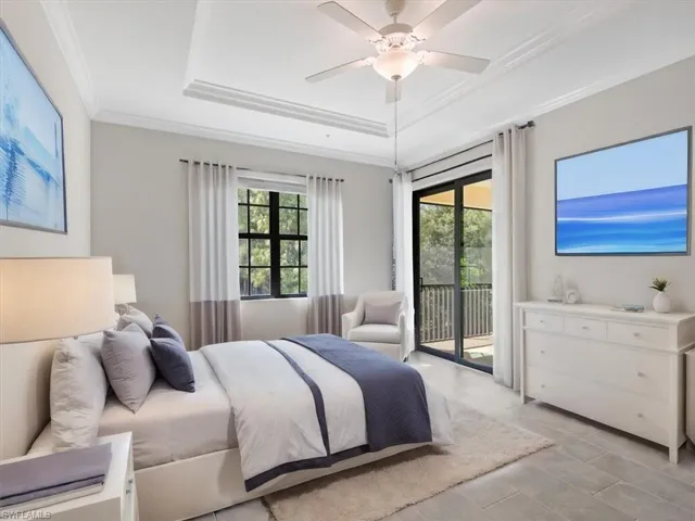 Owners Bedroom featuring ceiling fan, a tray ceiling, access to outside, and ornamental molding, virtually staged